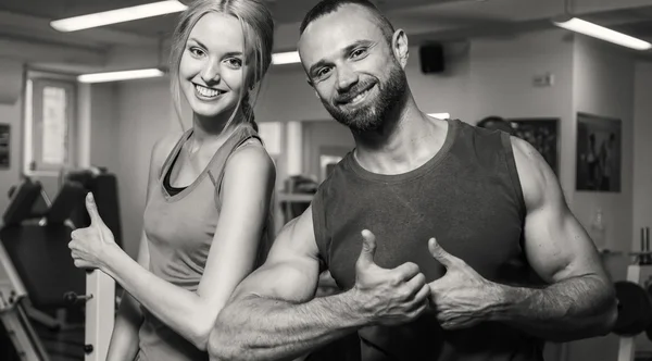 Sport couple on training in the gym. Healthy life. Help and support when performing exercises. Photos for sporting magazines and websites.