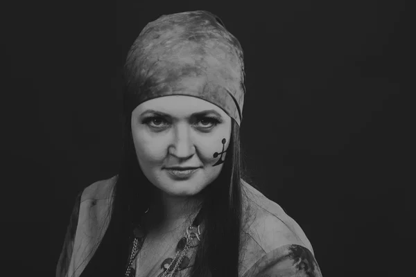 Beautiful gypsy girl on a black background, black and white photo