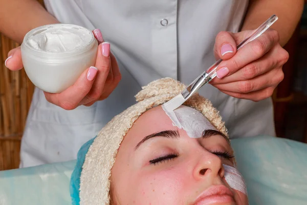 Beauty treatments for problem skin. The girl in the spa salon, applying cream.