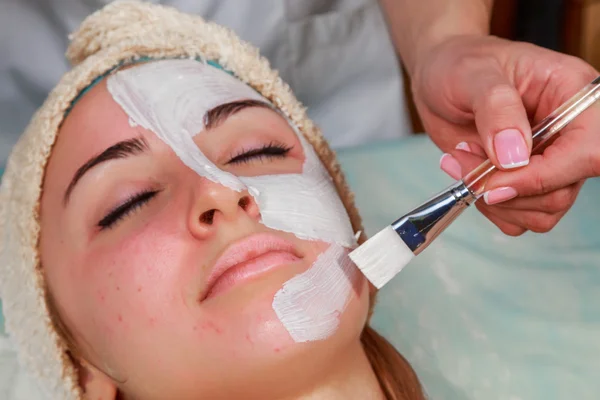 Beauty treatments for problem skin. The girl in the spa salon, applying cream.