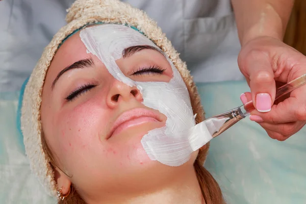Beauty treatments for problem skin. The girl in the spa salon, applying cream.
