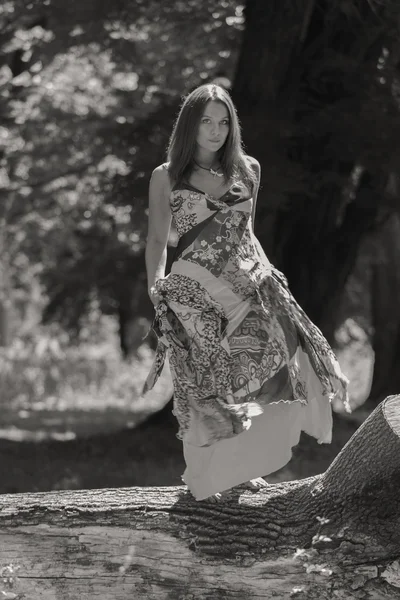 Young brunette woman in a white dress. A girl stands in the middle of pink flowers field on a sunny day. Field, flowers beauty, nature, - The concept of country vacation. Article about vacation.