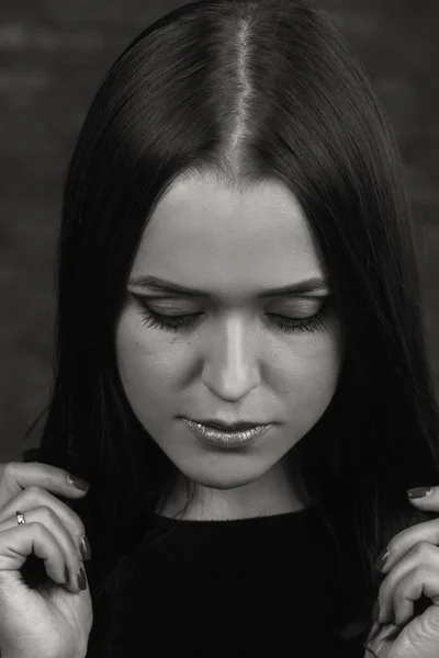 Beautiful, mysterious, cute brunette on a dark background. Black and white photo Beautiful mysterious brunette.