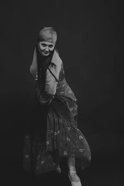 Beautiful gypsy girl on a black background, black and white photo