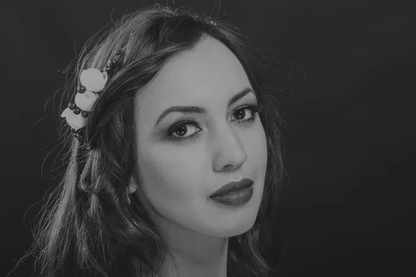 Pretty brunette with a wreath in her hair, black-and-white photo