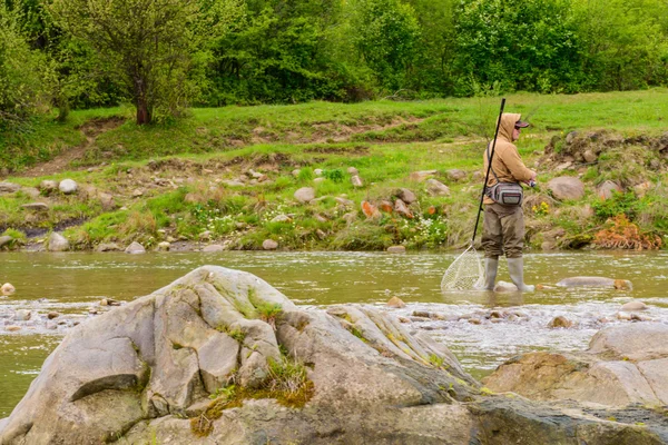 Fishing on the mountain river. Trout fishing. Fisherman fishing