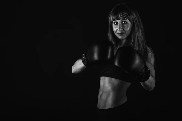 The girl with a beautiful body trained in boxing gloves