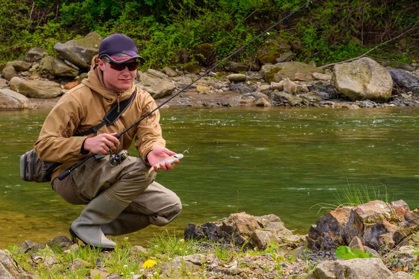 A fisherman caught trout on the mountain river