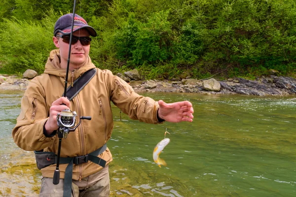 A fisherman caught trout on the mountain river