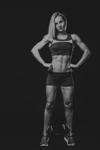 Fitness girl posing on black