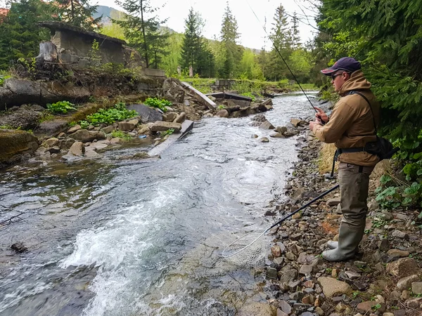 A fisherman caught trout on the mountain river