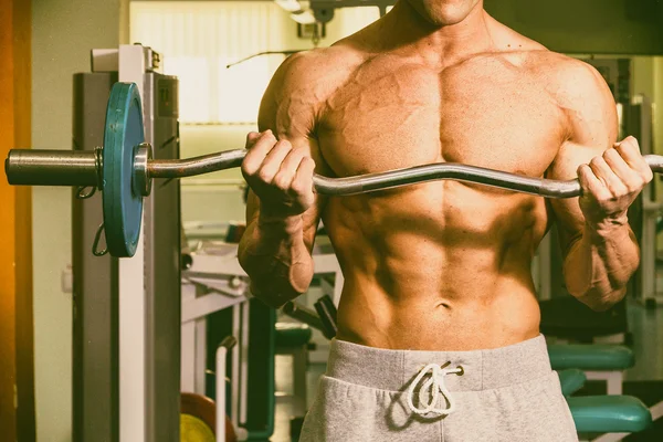 A man with a barbell exercise on biceps