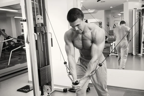 Man makes exercises at  gym