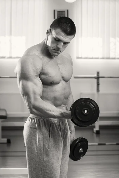 Muscular man working out with dumbbells