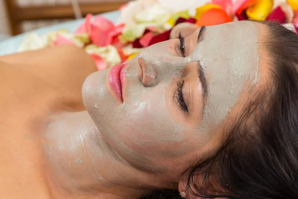 Beautiful woman with facial mask at beauty salon.