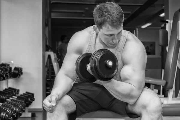 Man with muscular arms holding a dumbbell