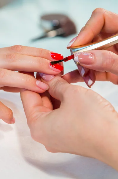 Woman applying nail varnish to nails