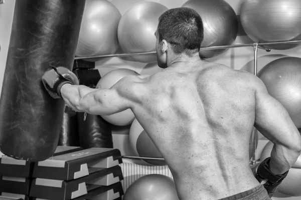 Muscular man in boxing gloves in gym