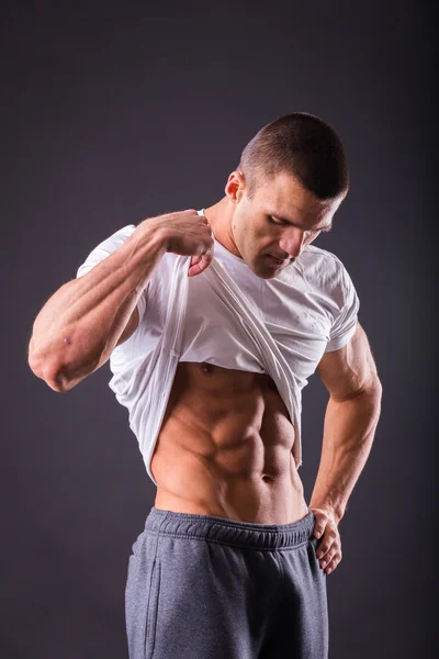 Man shows his abdominal muscles