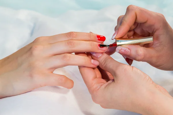Woman applying nail varnish to nails