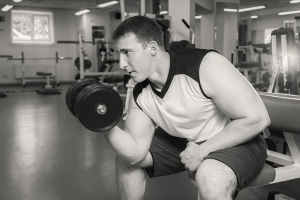 Man with muscular arms holding a dumbbell