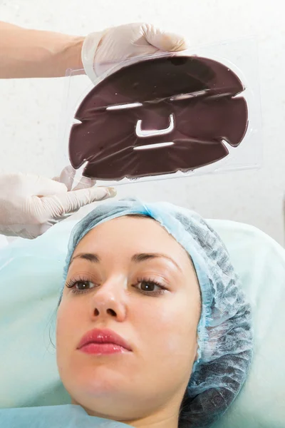 Woman receiving silicone facial mask