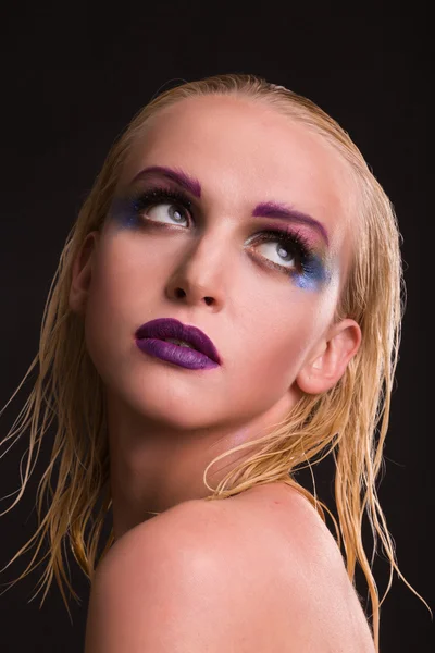 Beautiful model with art makeup on a dark background