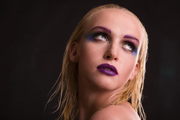 Beautiful model with art makeup on a dark background