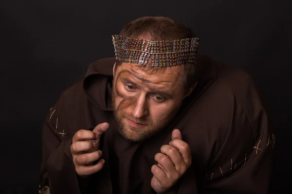 The actor in the guise of a beggar on a dark background