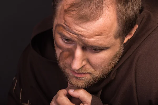 The actor in the guise of a beggar on a dark background