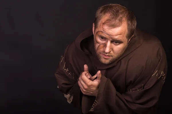 The actor in the guise of a beggar on a dark background