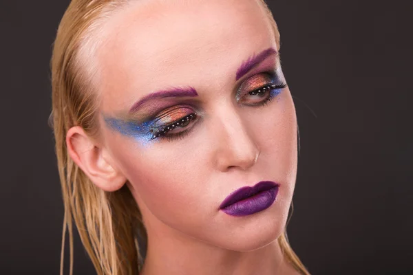 Beautiful model with art makeup on a dark background