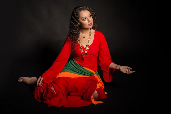 Beautiful brunette in the form of a gypsy on a dark background