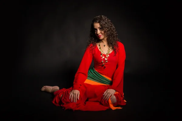 Beautiful brunette in the form of a gypsy on a dark background