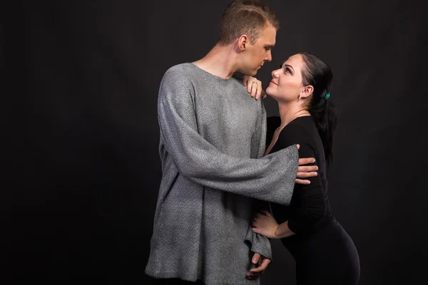 Young couple in love dancers on a dark background