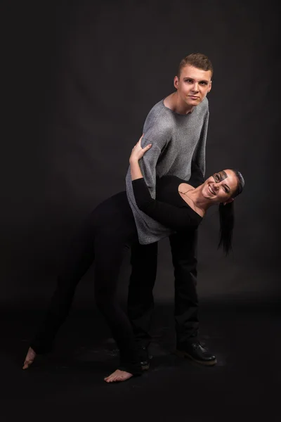 Young couple in love dancers on a dark background