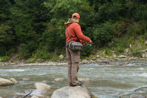 Fishing in the mountain river in summer