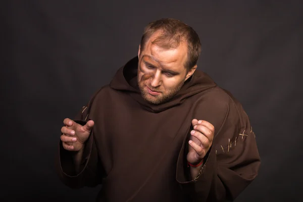 The actor in the guise of a beggar on a dark background