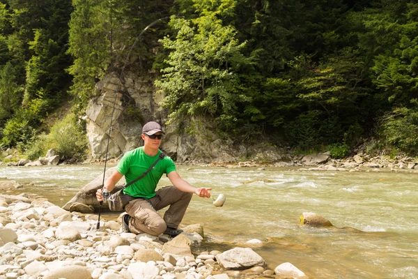 Fishing in the mountain river in summer