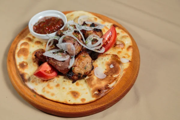 Appetizing roasted meat with vegetables on pita bread