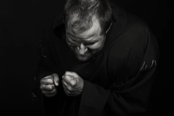 The actor in the guise of a beggar on a dark background