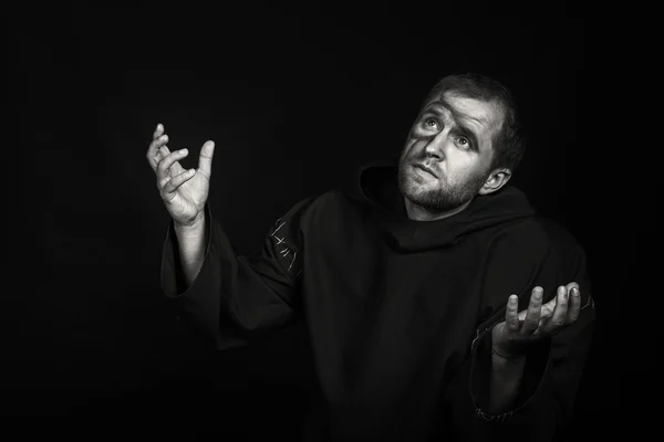 The actor in the guise of a beggar on a dark background