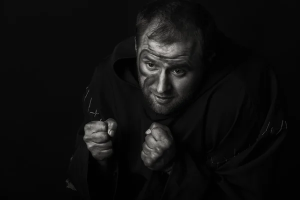 The actor in the guise of a beggar on a dark background