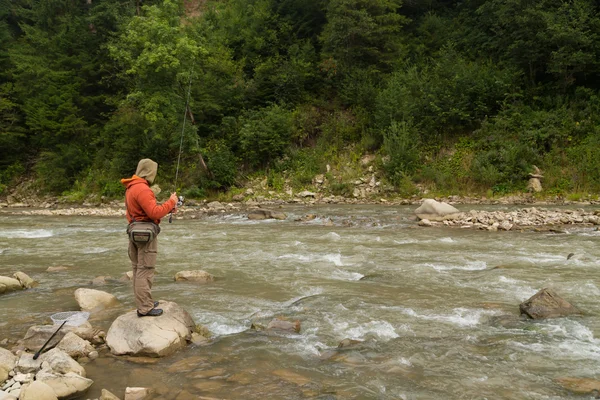 Fishing in the mountain river in summer