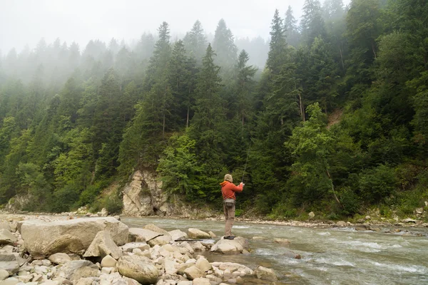 Fishing in the mountain river in summer