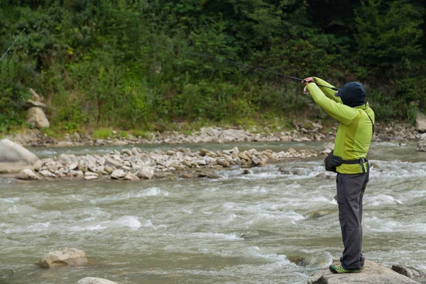 Fishing in the mountain river in summer