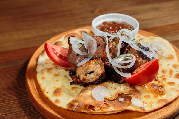 Tasty meat dish with vegetables on pita bread