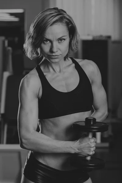 Sport blonde. Beautiful strong girl. Bodyfitness, women\'s fitness. Woman doing exercises at the gym. Beauty, health, and sports.Bodybuilder young adult sexy girl