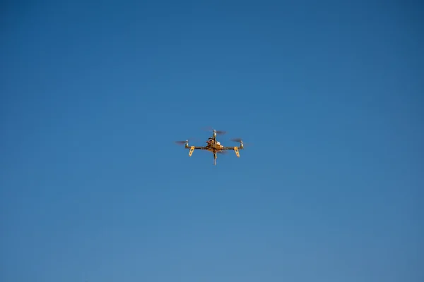 One small drone with blue sky on background.
