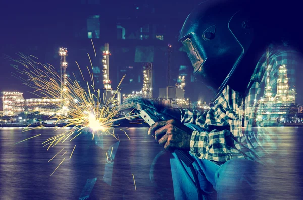 Welder at work with Oil and gas refinery